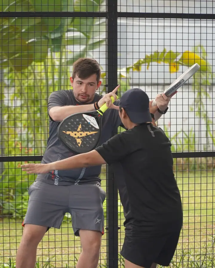 A coach guiding a player's swing