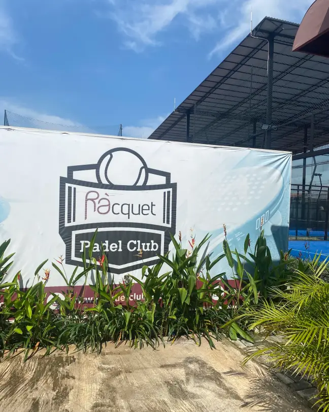 The Ràcquet Padel Club crest on a wall in the garden